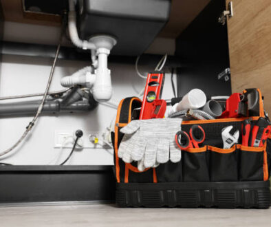 Plumber's tool bag on floor under kitchen sink
